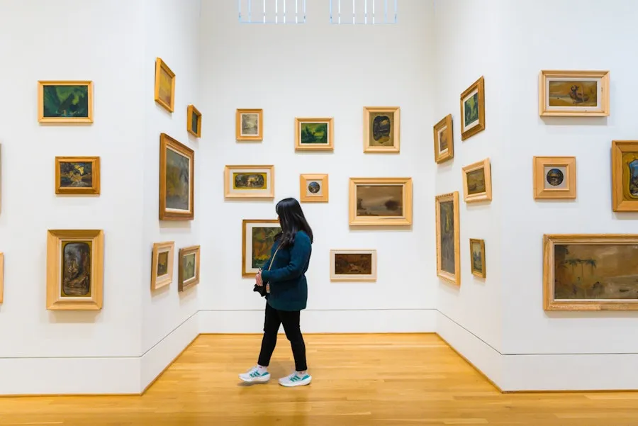 Visitor views framed paintings in white Phillips Collection gallery with wood floor