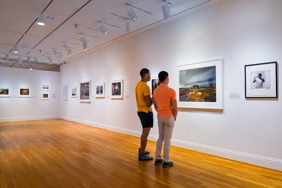 Two visitors view framed photos in a bright gallery in The Phillips Collection