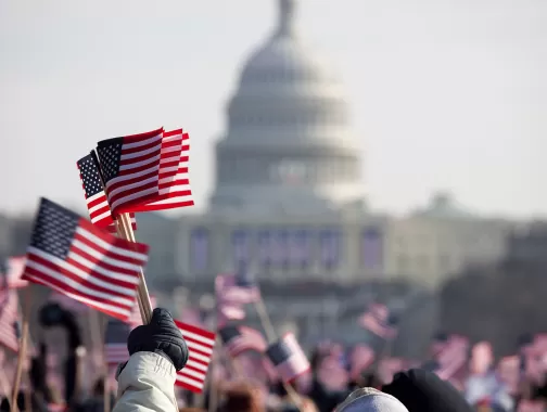 US Capitol with waving American flags