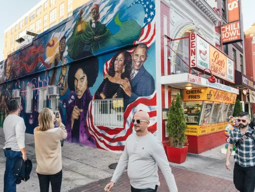 Guests Taking Photo of Ben's Chili Bowl Mural