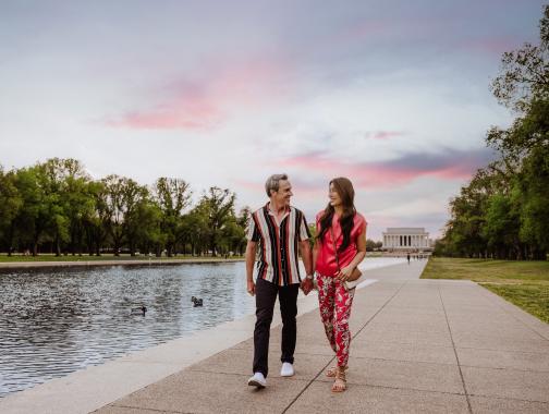 Couple walking by reflecting pool in front of Lincoln Memorial
