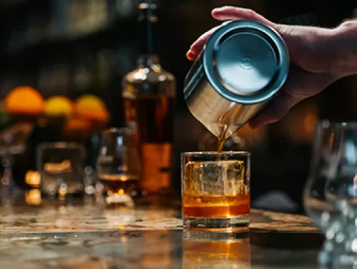 Camarero sirviendo whisky en un vaso