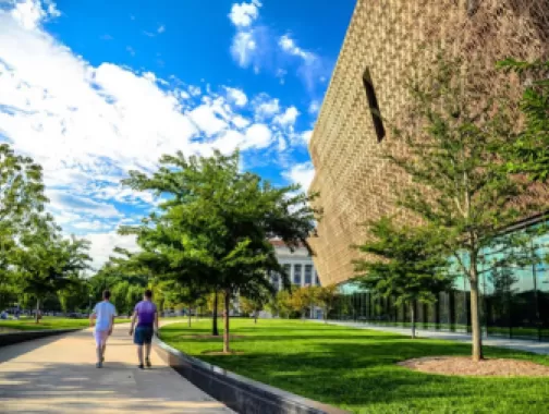 Gente caminando afuera frente al Museo Nacional de Historia y Cultura Afroamericana