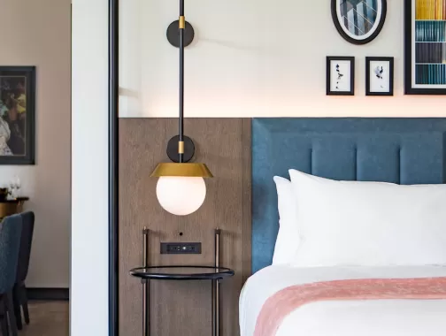 Guest room at Royal Sonesta Capitol Hill with a bed, modern decor, and a dining area in the background.
