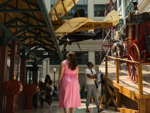 Visitors explore historic transportation displays inside the Smithsonian National Postal Museum.