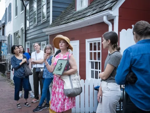 A tour guide speaks to a group during a historic walking tour in Georgetown, Washington, DC.