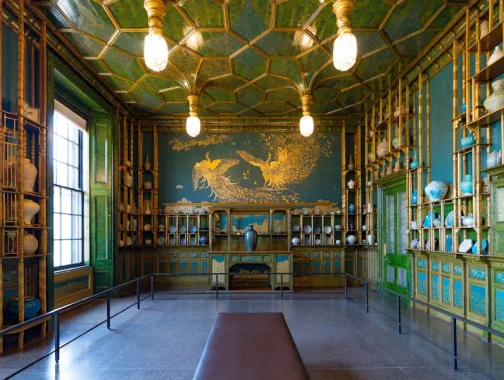 La Sala del Pavo Real de la Galería Freer está decorada con paredes de color azul verdoso, detalles dorados y exhibiciones de porcelana.