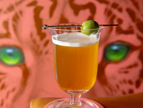 Pink and orange cocktail on a coaster at Elegancia