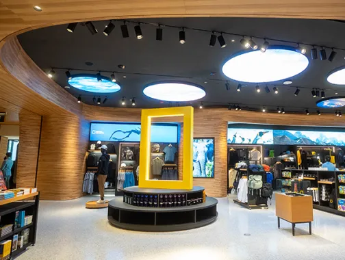 Museum store interior with a yellow kiosk under a circular skylight