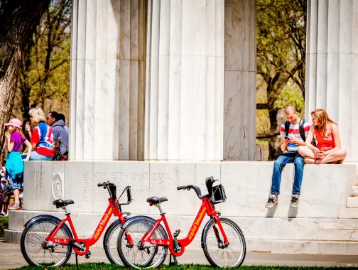 Pareja con Capital Bikeshare Bikes en DC War Memorial - Washington, DC