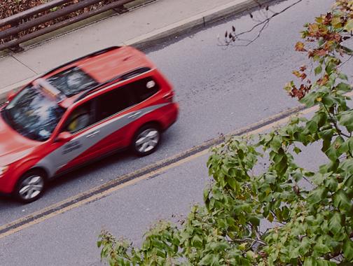 red taxi car driving on the road