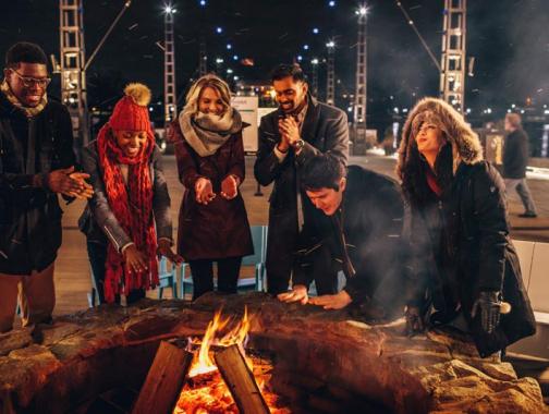 Amici riuniti intorno al fuoco al The Wharf - Modi per sfruttare al meglio l'inverno a Washington, DC