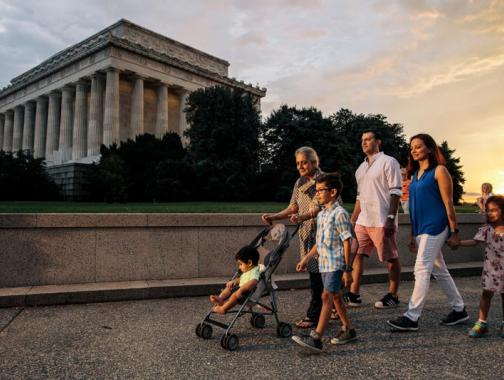 Famiglia che cammina sul National Mall di fronte al Lincoln Memorial durante una serata estiva a Washington, DC
