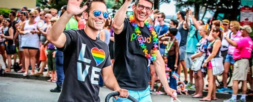 Paar zu Fuß mit Kind während der Capital Pride Parade - LGBTQ-Sommerveranstaltungen in Washington, DC