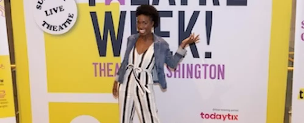 Frau posiert vor einem Banner der Theaterwoche.