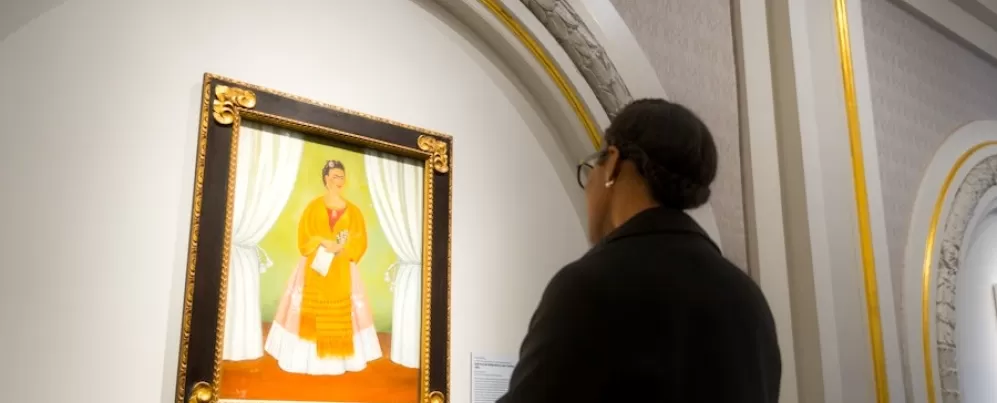 Une femme regarde un autoportrait de Frida Kahlo au Musée national des femmes dans les arts.