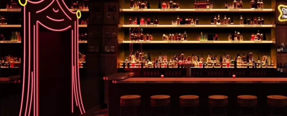 Un bar de estilo retro, poco iluminado, con una exhibición de licores retroiluminada, una fila de taburetes de madera y una entrada en forma de cortina de color rosa neón a la izquierda.