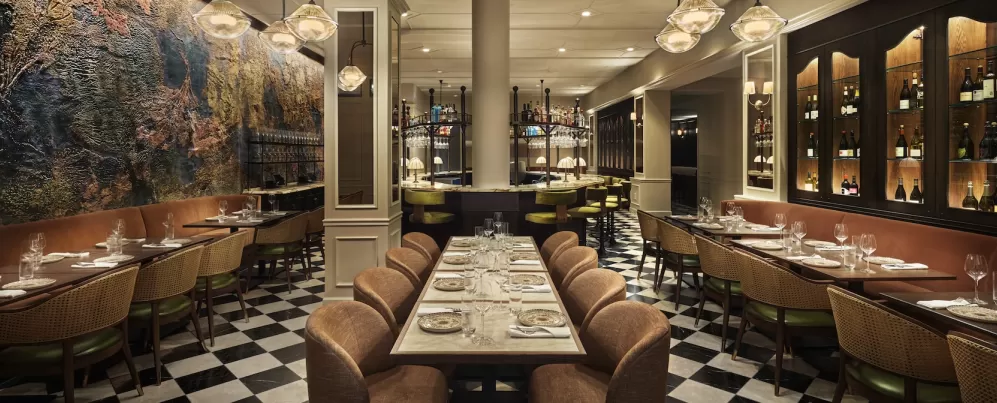 Intérieur de restaurant élégant au Sixty DC avec un éclairage chaleureux, une décoration moderne et un bar central avec des tabourets hauts.