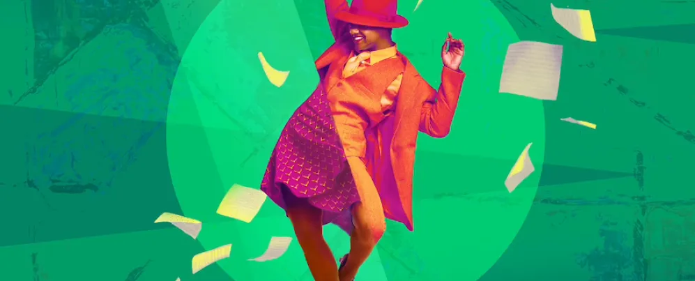 A joyful actor in period costumes dances energetically on stage.