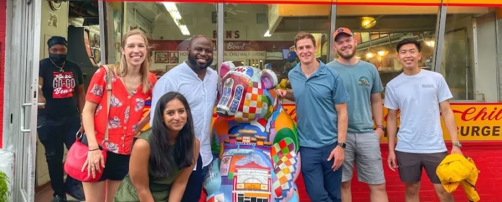 A group poses for a photo outside of Ben's Chili Bowl. 