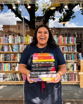 Mujer sonriente sosteniendo libros