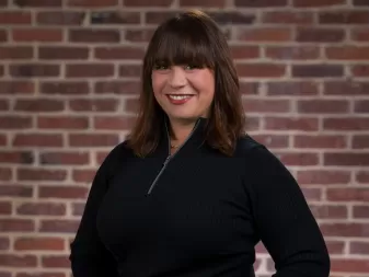 Uma mulher sorri para uma foto profissional. 