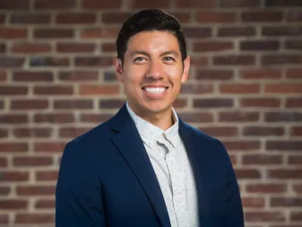 headshot_aaron-chavez-in-blazer-blu-contro-il-muro-di-mattoni_ddc