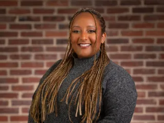 Une femme sourit pour une photo professionnelle. 