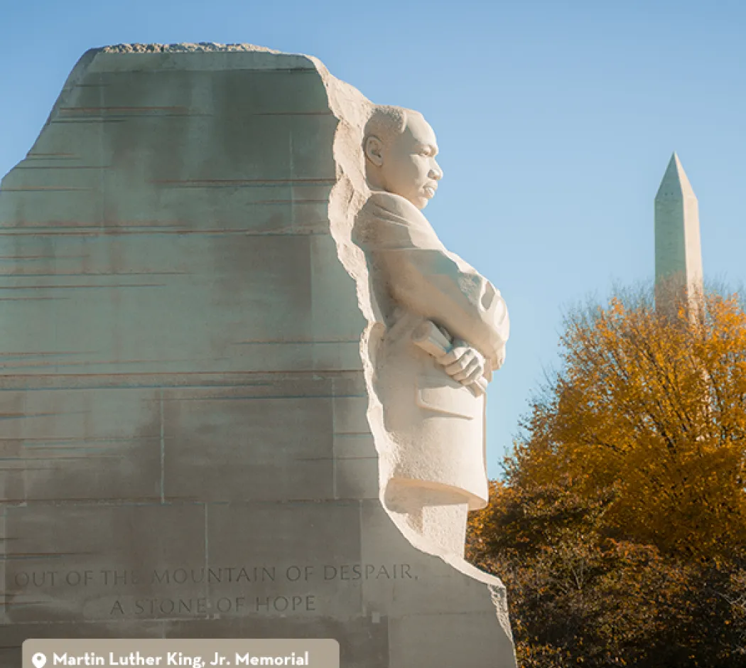 Martin Luther King Jr. Memorial statue with Washington Monument behind, autumn trees