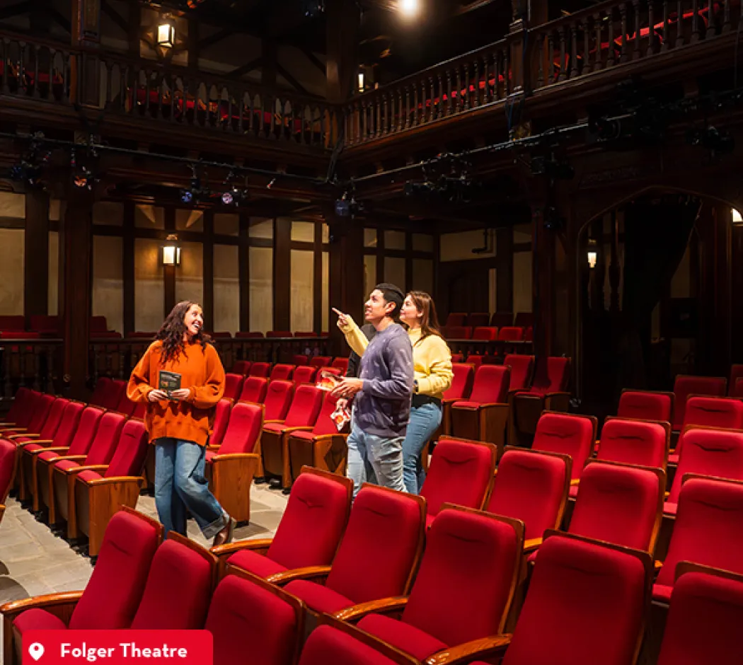 Three people chatting among red seats inside Ford’s Theatre