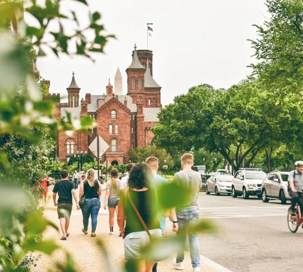 I visitatori a piedi dal castello Smithsonian sul National Mall di Washington, DC